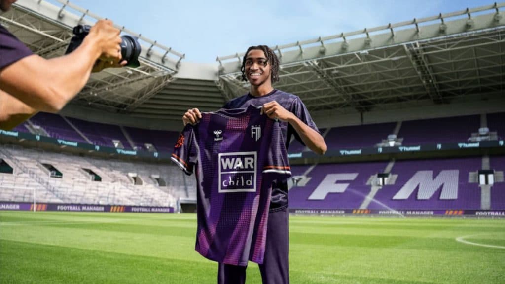 Football Manager 2024 signing holding shirt.