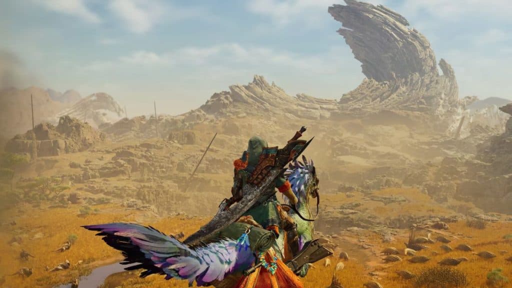 monster hunter wilds character on mount overlooking desert landscape